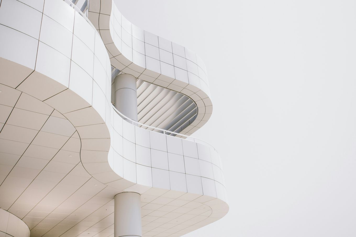 White curved facade with balconies, seen from below